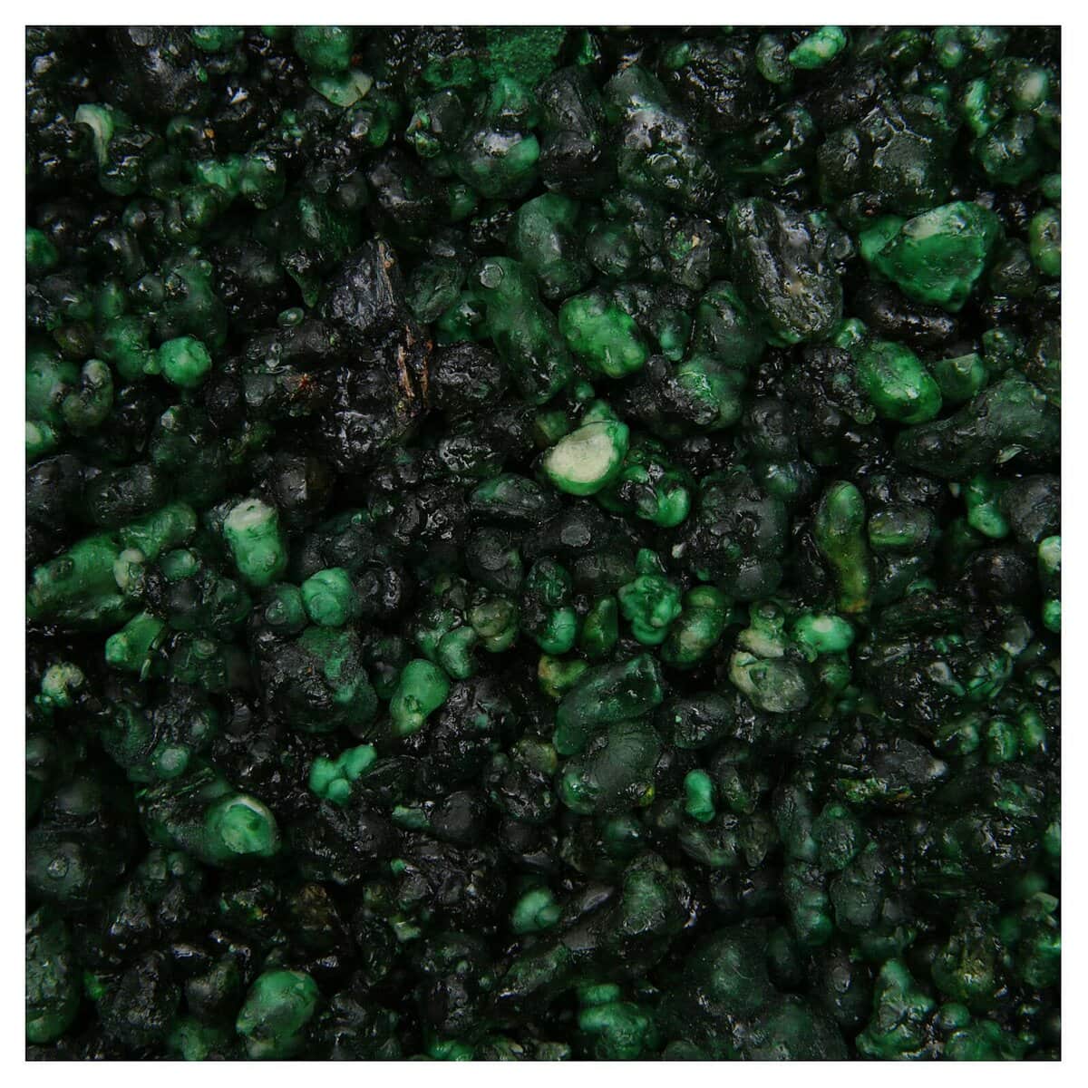 Prim plan al Lemnului de cedru / Tămâie Cedarwood, care prezintă o suprafață texturată cu pietricele strânse, neregulate, de culoare verde închis și negru, evocând frumusețea robustă a lemnului de cedru.