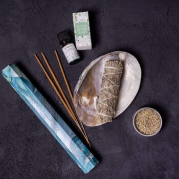 Set Salvie Albă include bețișoare de salvie albă, suport pentru bețisor, ulei esențial, o cutiuță și plante uscate, toate așezate elegant-ideal pentru curățare și purificare.